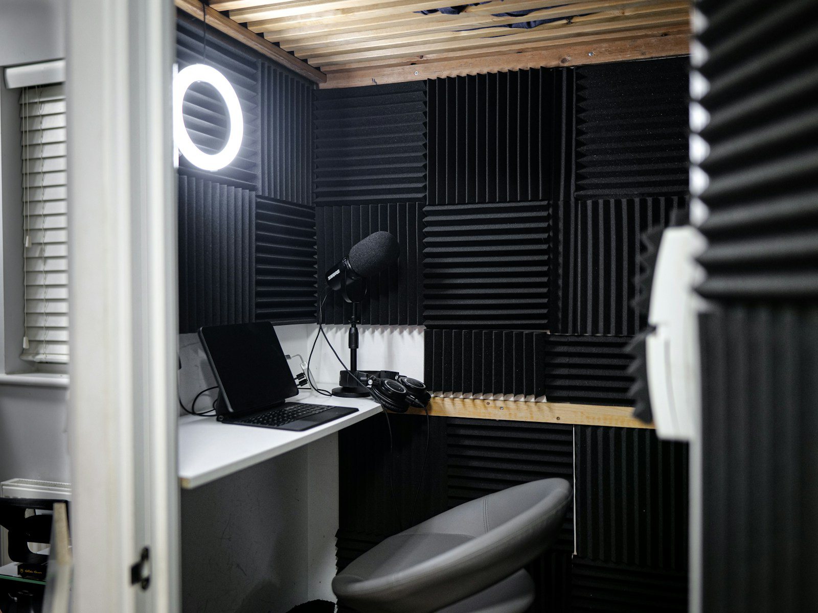 Three upright screens on a dark desk showing the same vertical clip in coral and cyan light